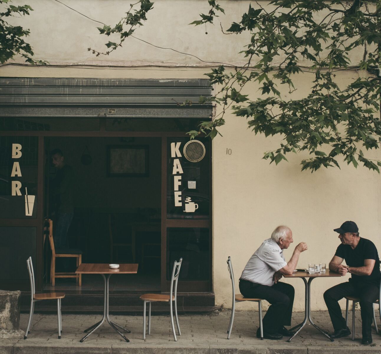 Two old men talking at a cafe