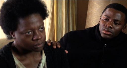  Viola Davis as Eva May sitting indoors, looking emotionally guarded and withdrawn in a scene from 'Antwone Fisher'.