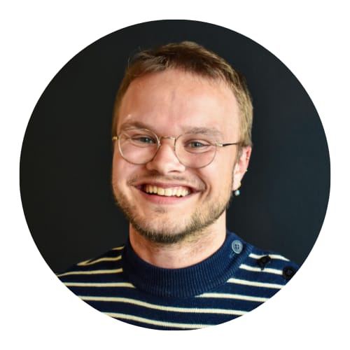 Profielfoto van Pim waarop hij breed lacht in de camera met een zwarte achtergrond