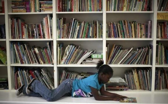 A homeless girl reads a book at a School on Wheels' after-school program in Los Angeles