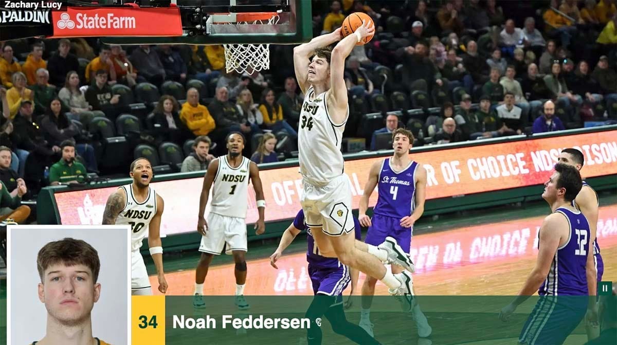 A basketball player in a white uniform leaps to dunk the basketball in an NCAA Division I game featuring North Dakota State University and the University of St. Thomas.