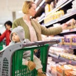 Casualy Dressed Mother Choosing Products In Department Of Superm
