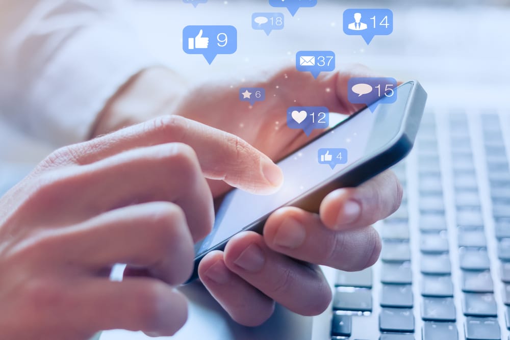 close up of hands holding smartphone engaging online vervology