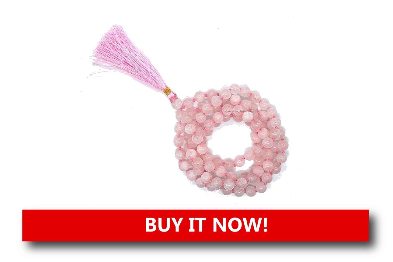 Rose Quartz Prayer Beads Alt text: Soft pink rose quartz prayer beads featuring a silver cross pendant, tied with a festive red ribbon and arranged gently on a holiday background.