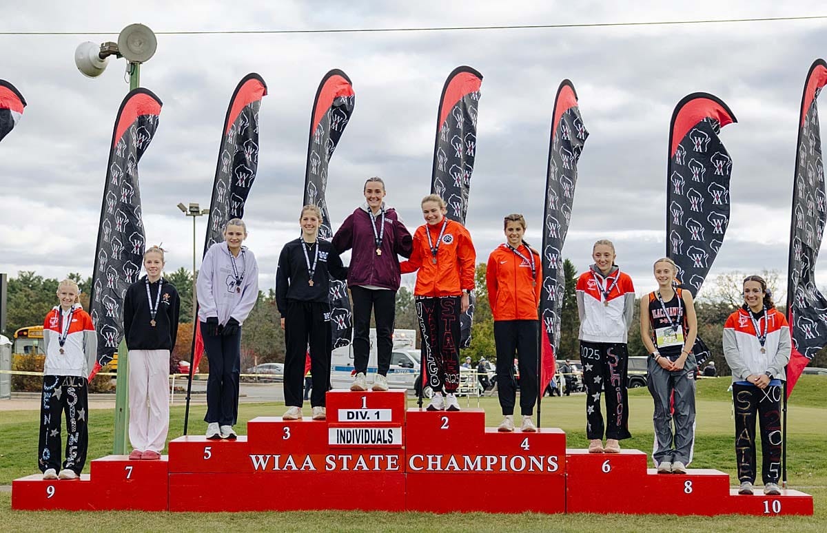 The top 10 finishers at the 2025 WIAA Division 1 Girls Cross Country Championship with Lauren McCalla on the top step.