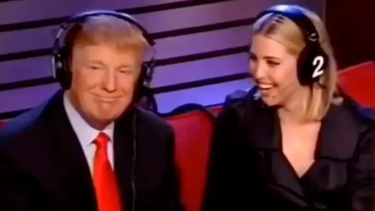 A white woman smiles brightly as she looks to her left at a white man grinning.