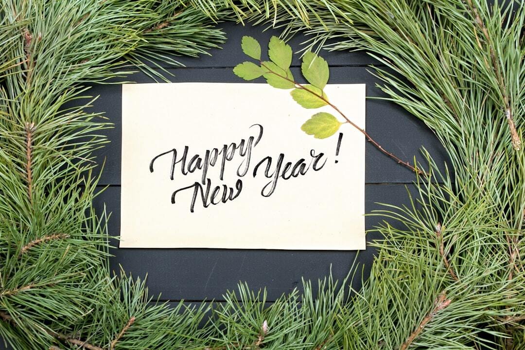 New Year Greeting Card. Christmas Tree On Wooden Background with Piece of Paper and Note