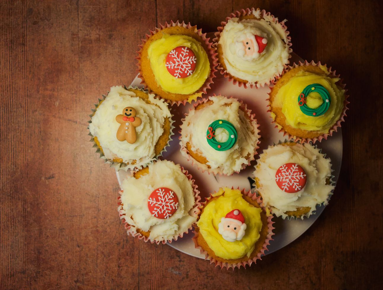 A batch of Christmas cupcakes on an antique wooden table