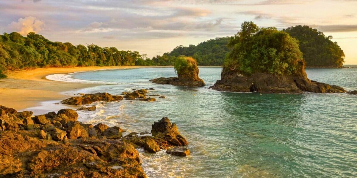 rock formations coming out of the water by a beach in Costa Rica