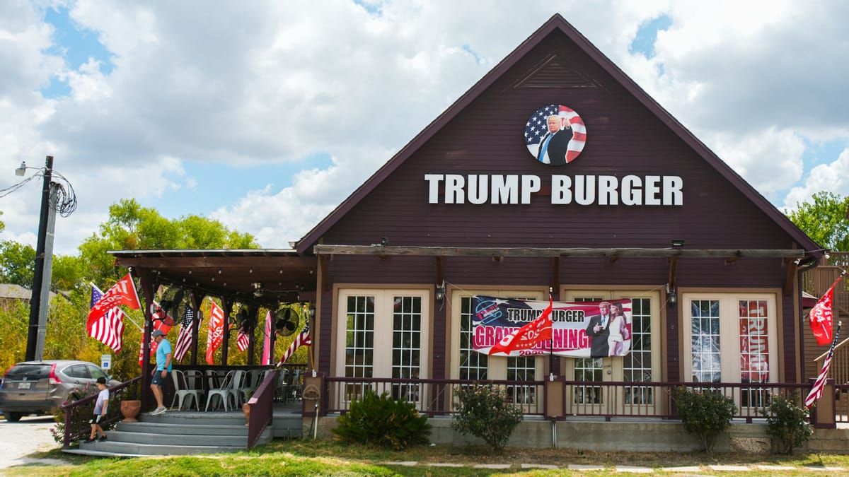 A building is pictured that says TRUMP BURGER. Several red, white and blue American flags can be seen around it.