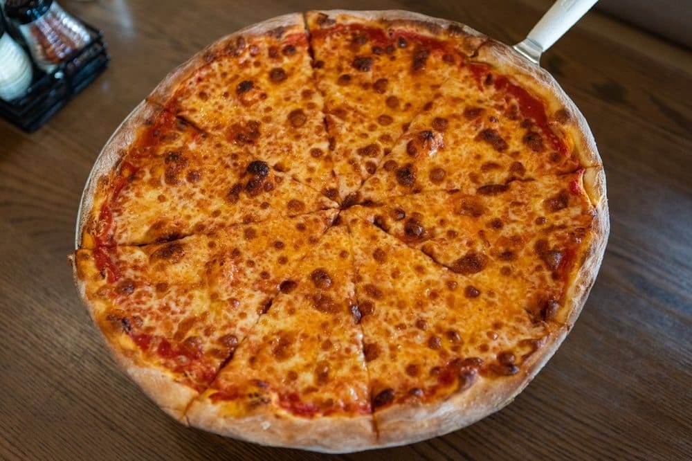 A pizza sitting on top of a wooden table.