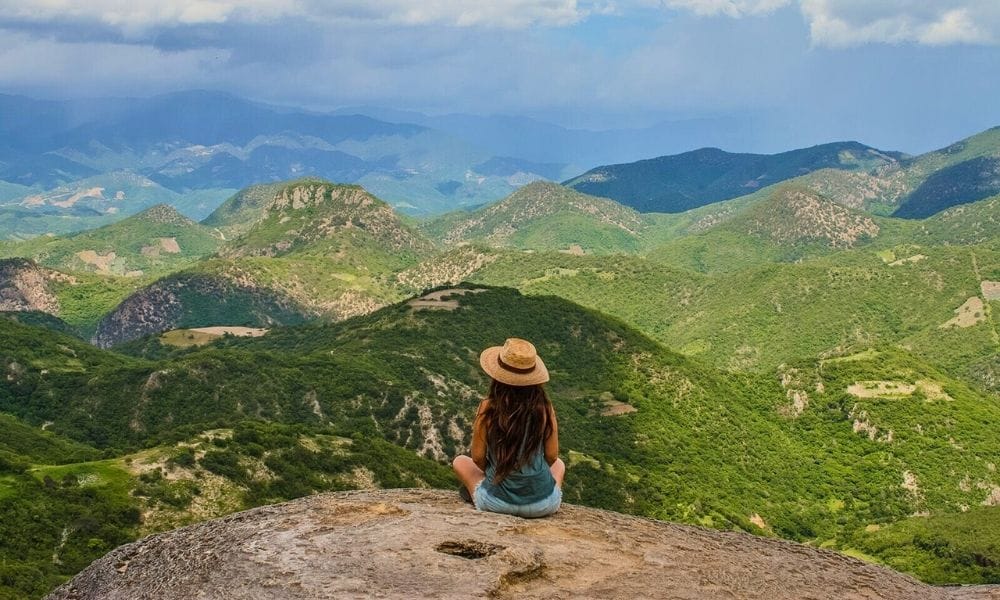 a girl sitting overlooking mountains