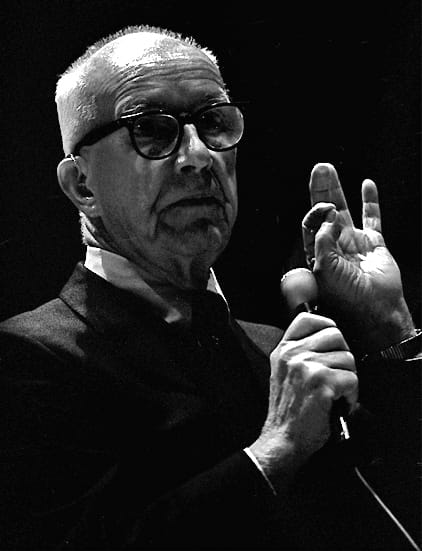 Black-and-white photo of Buckminster Fuller speaking—icon of visionary design and trim tab philosophy for world-changing leaders.