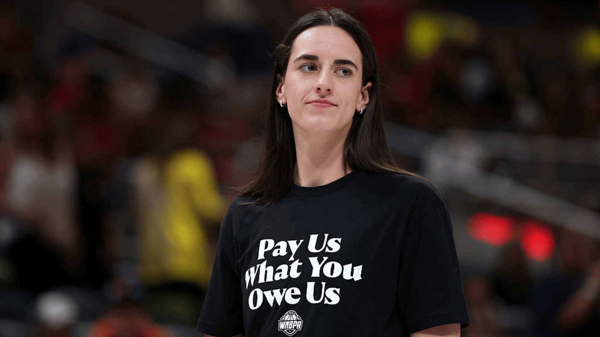 Caitlin Clark #22 of the Indiana Fever wears a shirt saying "Pay us what you owe us" prior to the 2025 AT&T WNBA All-Star Game at Gainbridge Fieldhouse on July 19, 2025 in Indianapolis, Indiana.