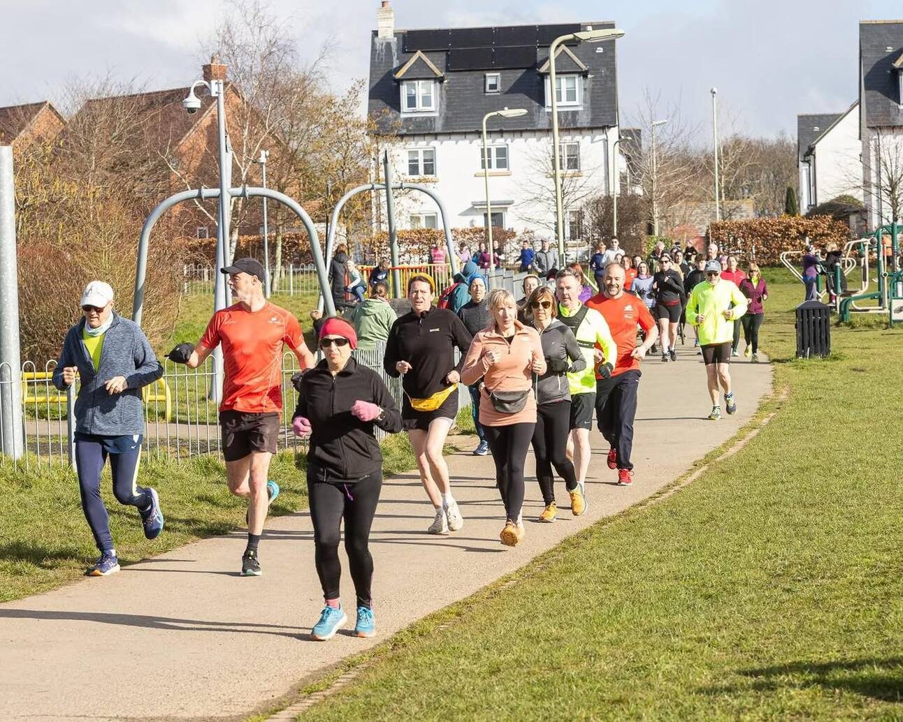 Parkrun - a group running along the path on the meadowside