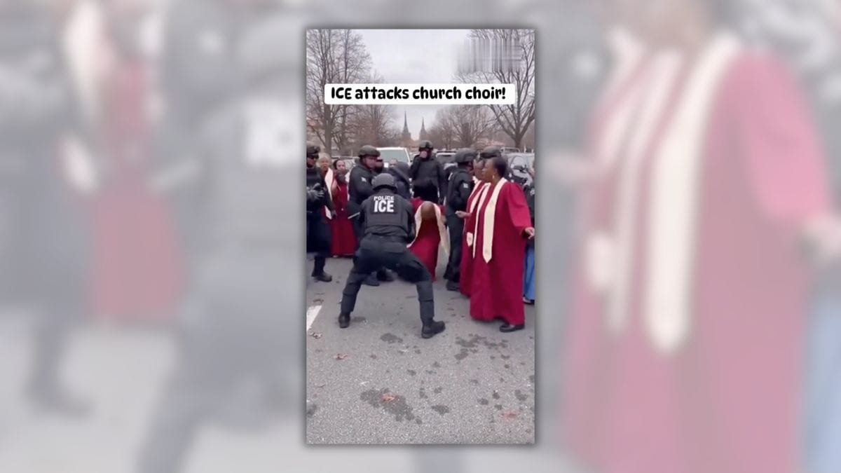 A crowd of people stand in a parking lot. Most of the people are wearing long red robes. One of the people with their back to the camera is wearing a top that says ICE. Text written on the video says "ICE attacks church choir!"