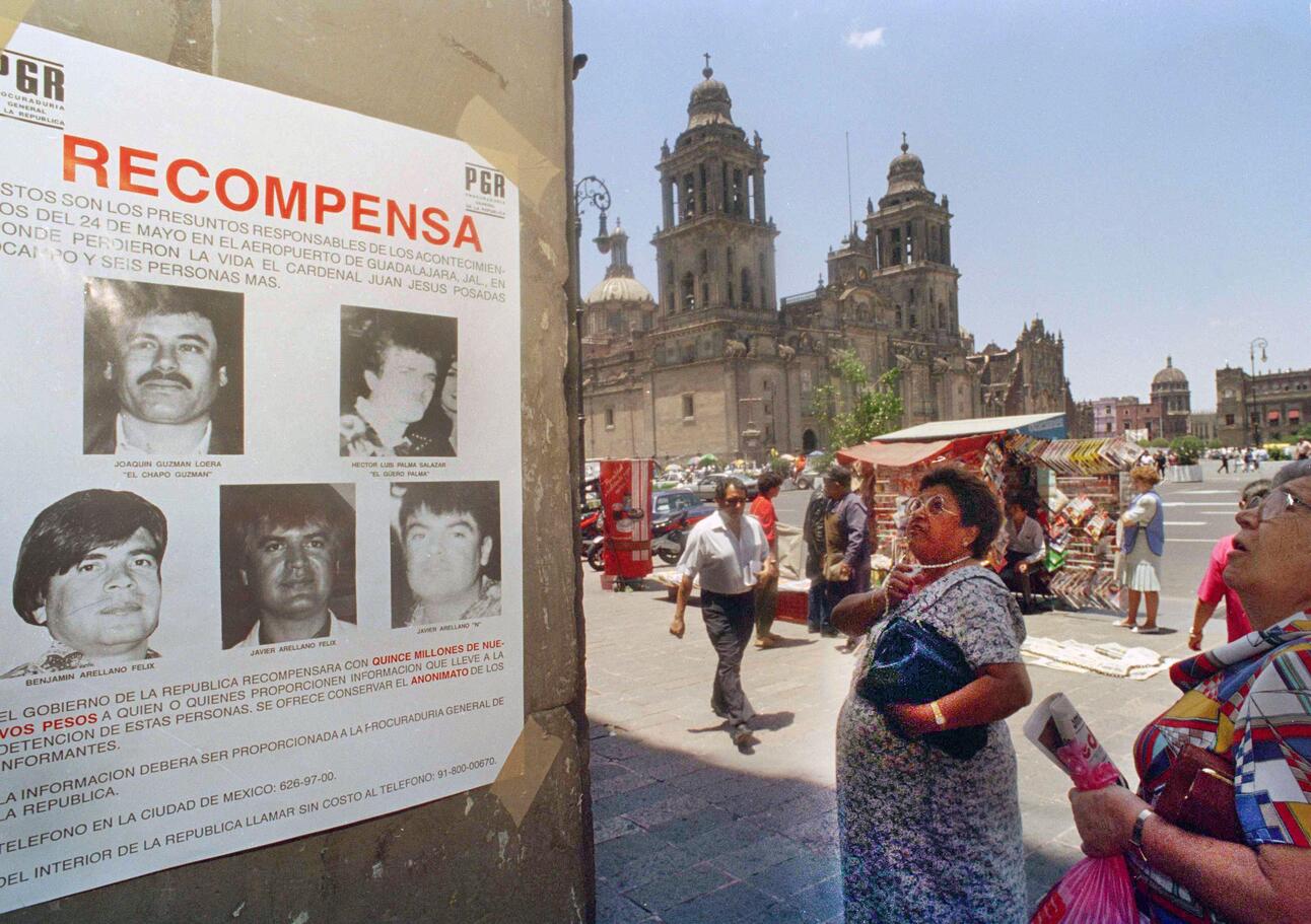 Two women reading wanted posters for head members of the Tijuana Cartel, one of the most notorious and violent cartels in the early 90s
