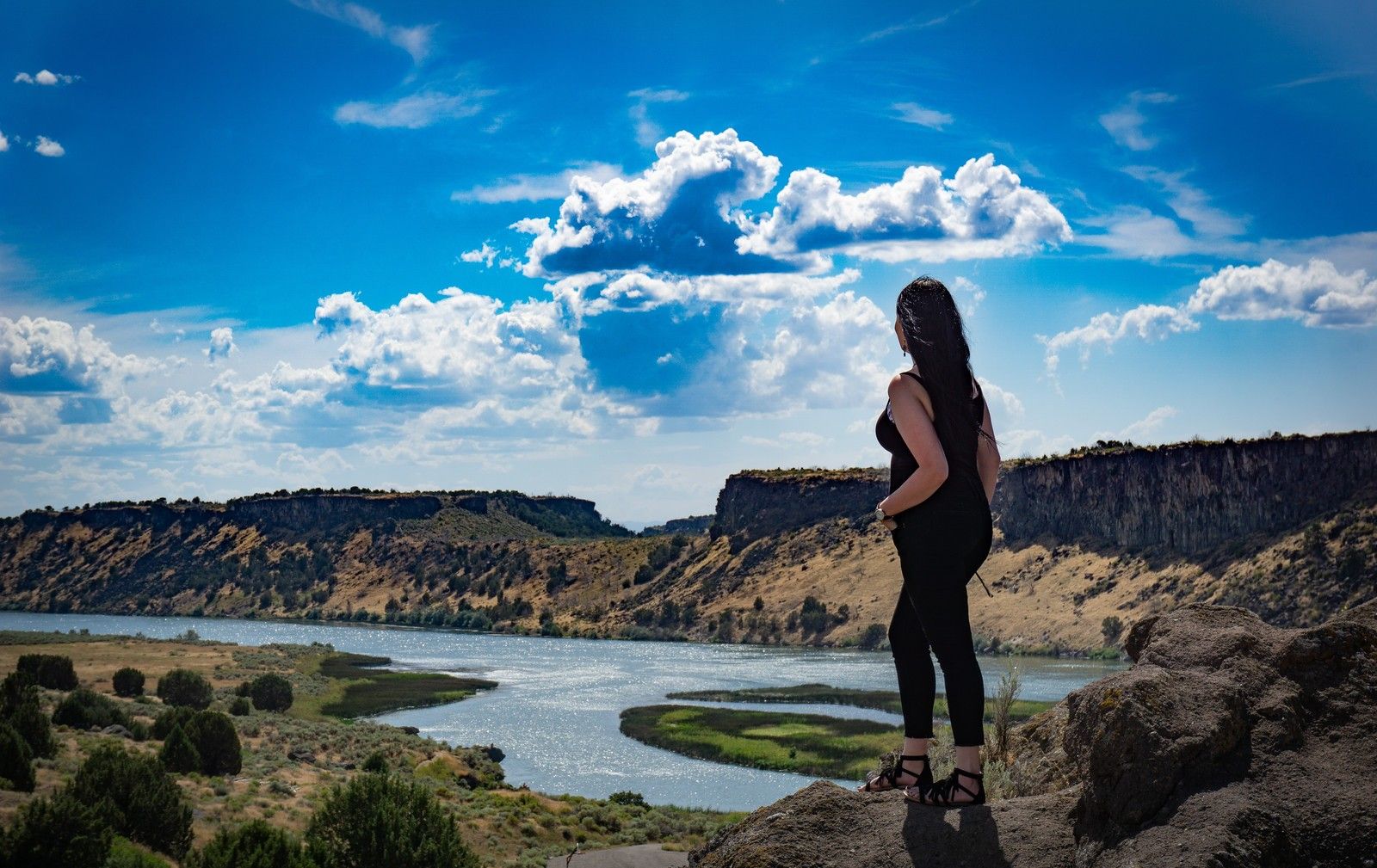 woman looks at landscape view from top of mountain hike