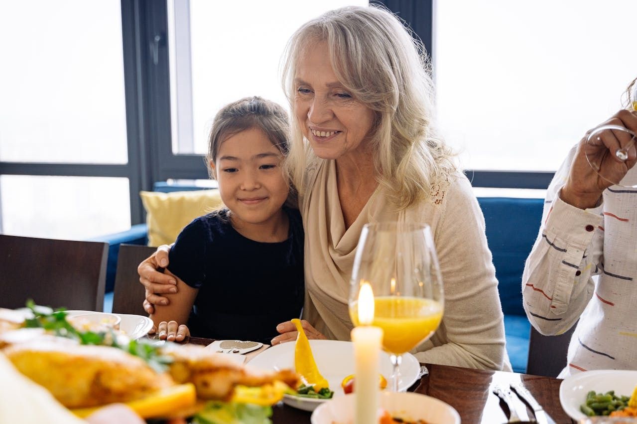 elderly lady hugging young girl at dinner