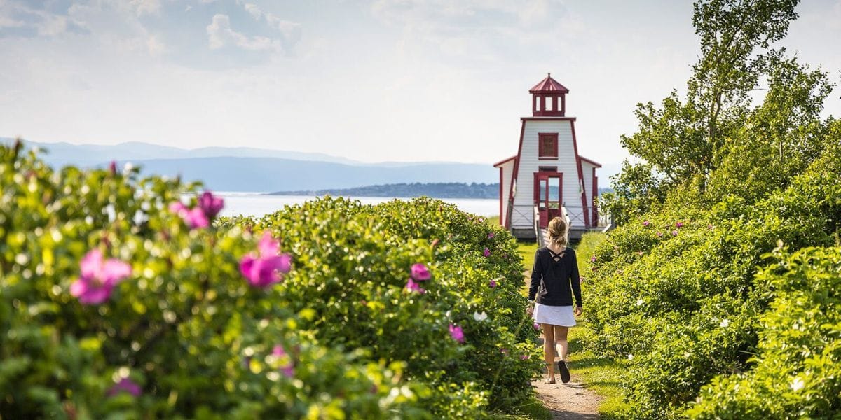a hiker walking to a costal lighthouse