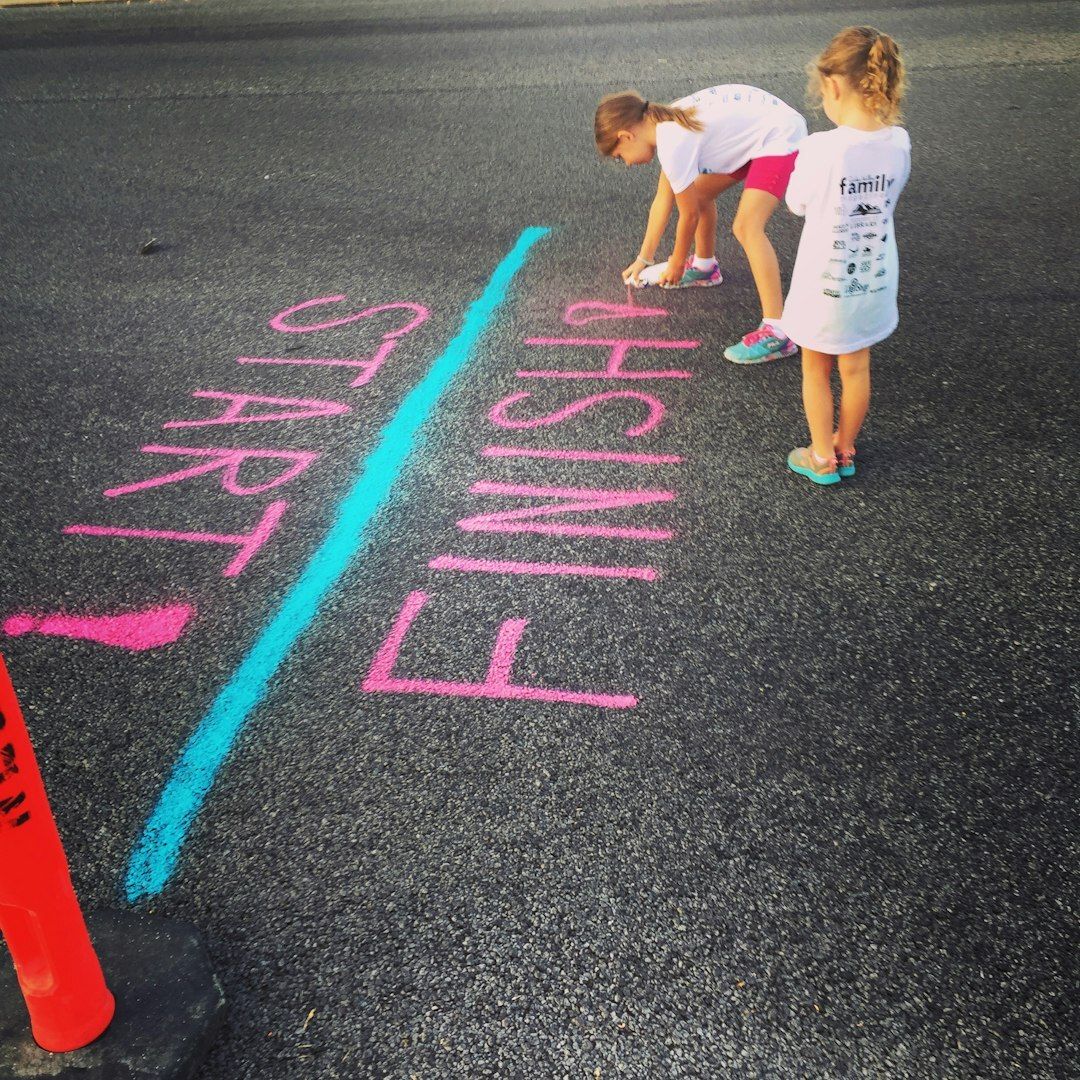 Two young girls mark a start/finish line using bright pink spray paint. Their efforts help get everything ready for a summertime 5k race in northern Utah. https://www.instagram.com/AwCreativeUT/ https://www.etsy.com/shop/AwCreativeUT #AwCreativeUT #awcreative 
