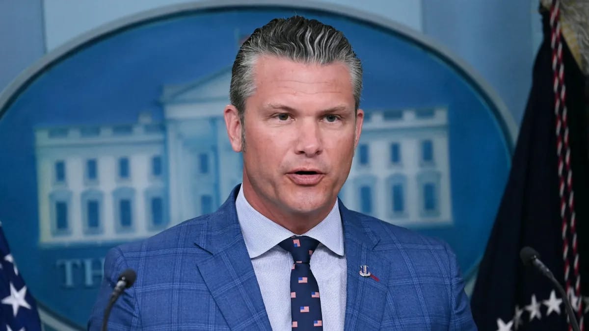A white man wearing a blue suit speaks.