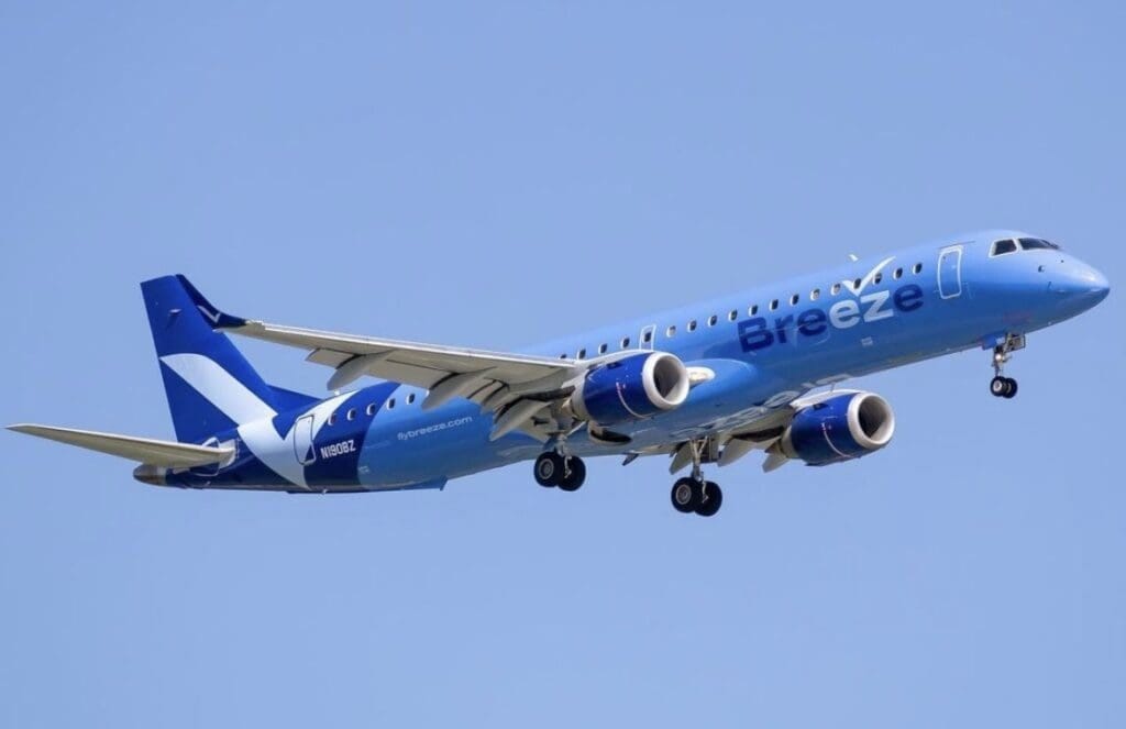 A blue and white airplane flying in the sky.