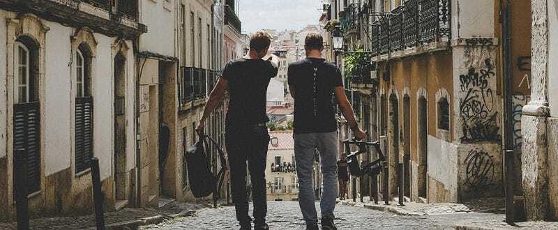 Two friends walking side by side down an empty road, deep in conversation — reflecting loyalty, trust, and shared journeys.