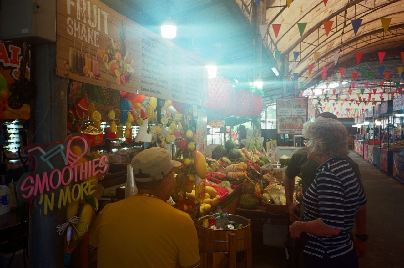 A fuit stall at a covered open-air market.