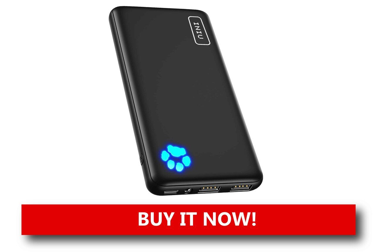 A Portable Charger That Keeps You Powered Up A slim, black power bank charging a smartphone and earbuds on an airport lounge table, with travel essentials like a passport and boarding pass nearby.