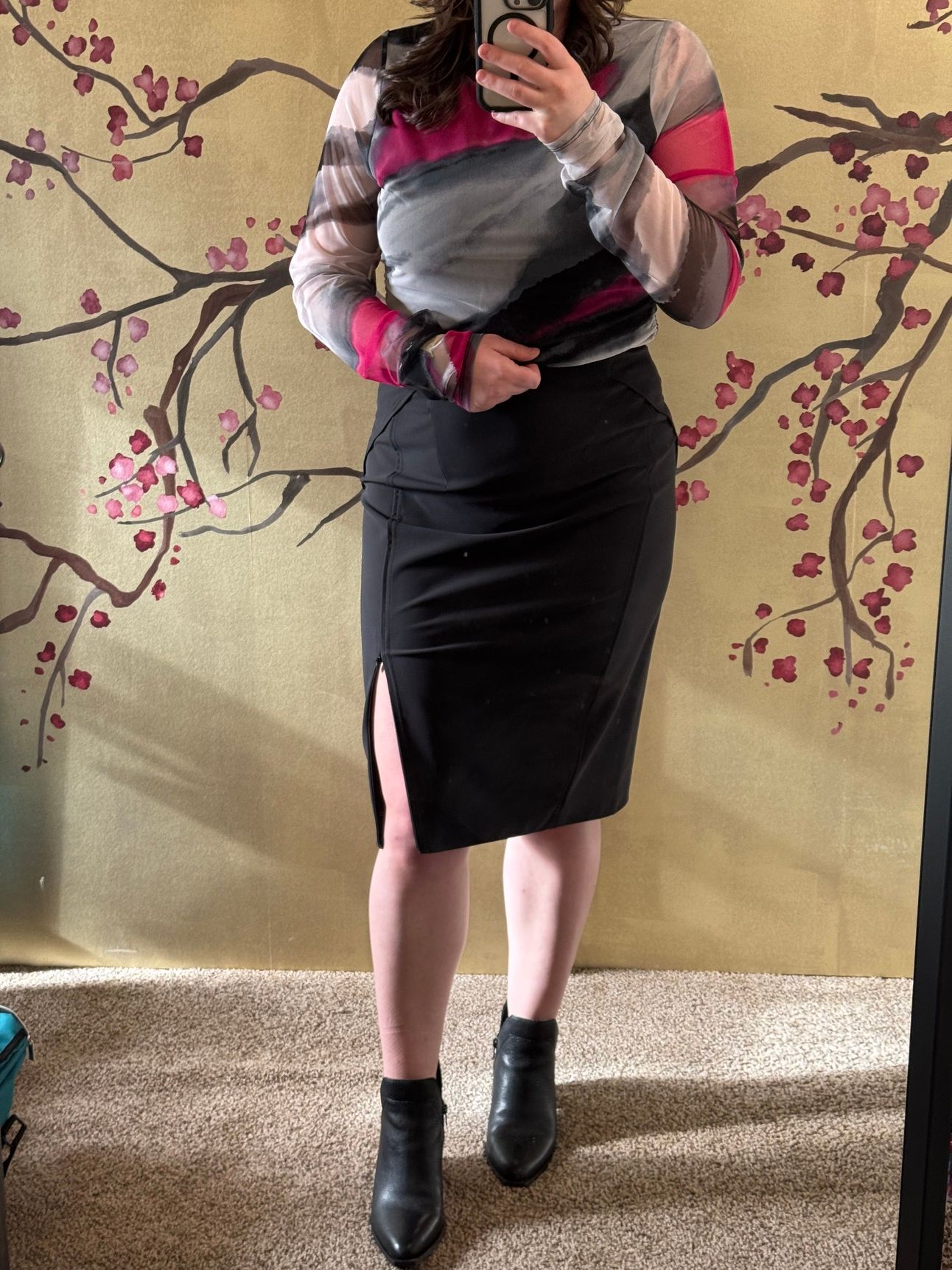 photo of a femine body in black pencil skirt and abstract black and pink top.