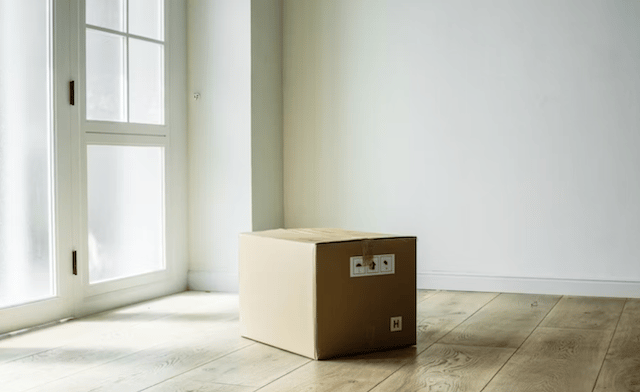 A cardboard packing box on the floor of an empty room
