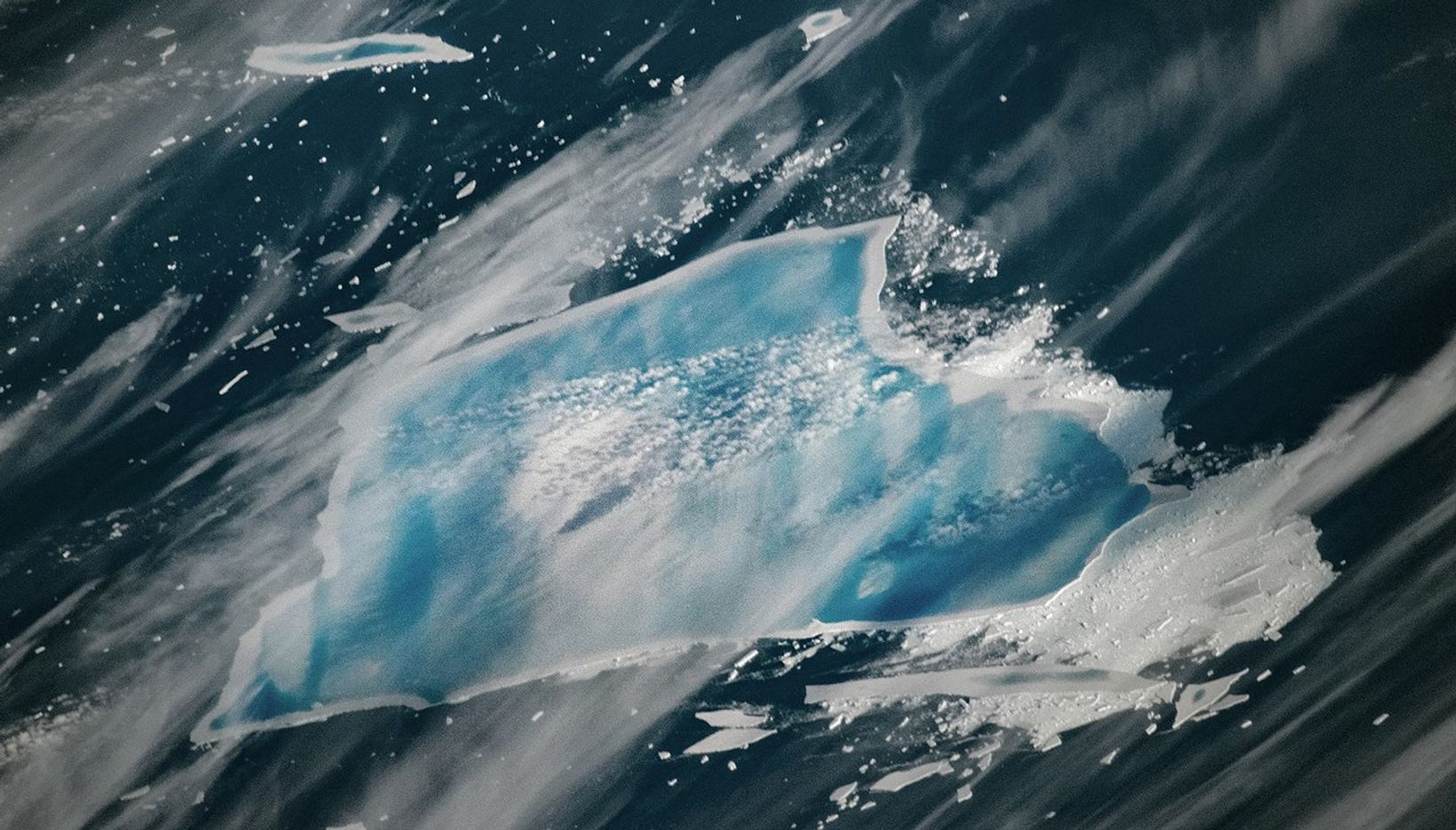 Once nearly twice the size of Rhode Island, it has shrunk to about 1,182 square kilometers after multiple breakups in 2025. Scientists note that its current state suggests the decades‑old iceberg is nearing complete disintegration. Its striking blue streaks come from surface meltwater pooling and refreezing in older, denser ice. When meltwater fills crevasses and refreezes without air bubbles, it absorbs red wavelengths and reflects blue, producing the vivid color seen in recent NASA imagery. 