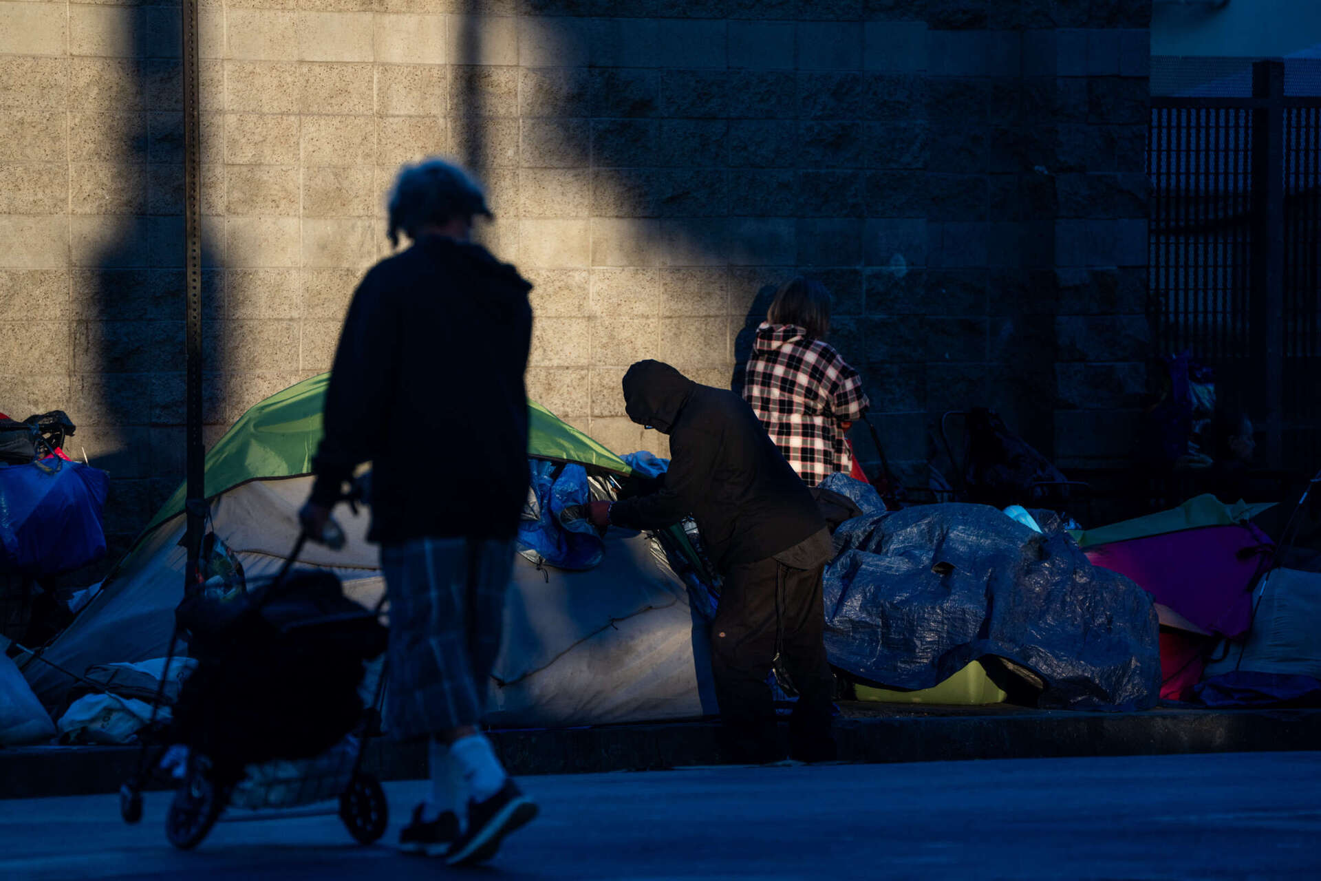 Unhoused individuals and tents are seen on a sidewalk in Los Angeles, California, on July 24, 2025. Qian Weizhong / VCG via Getty Images