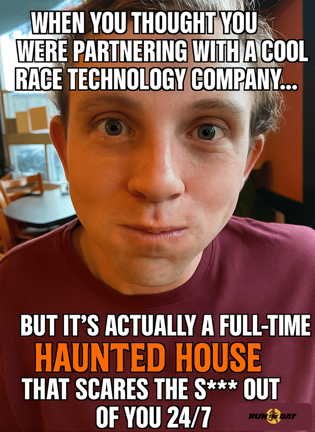 Close-up photo of a man with a startled expression and flushed face, overlaid with white and orange meme text that reads, “When you thought you were partnering with a cool race technology company… but it’s actually a full-time haunted house that scares the s*** out of you 24/7.” A small Run The Day logo appears in the corner, giving the image a humorous Halloween vibe.