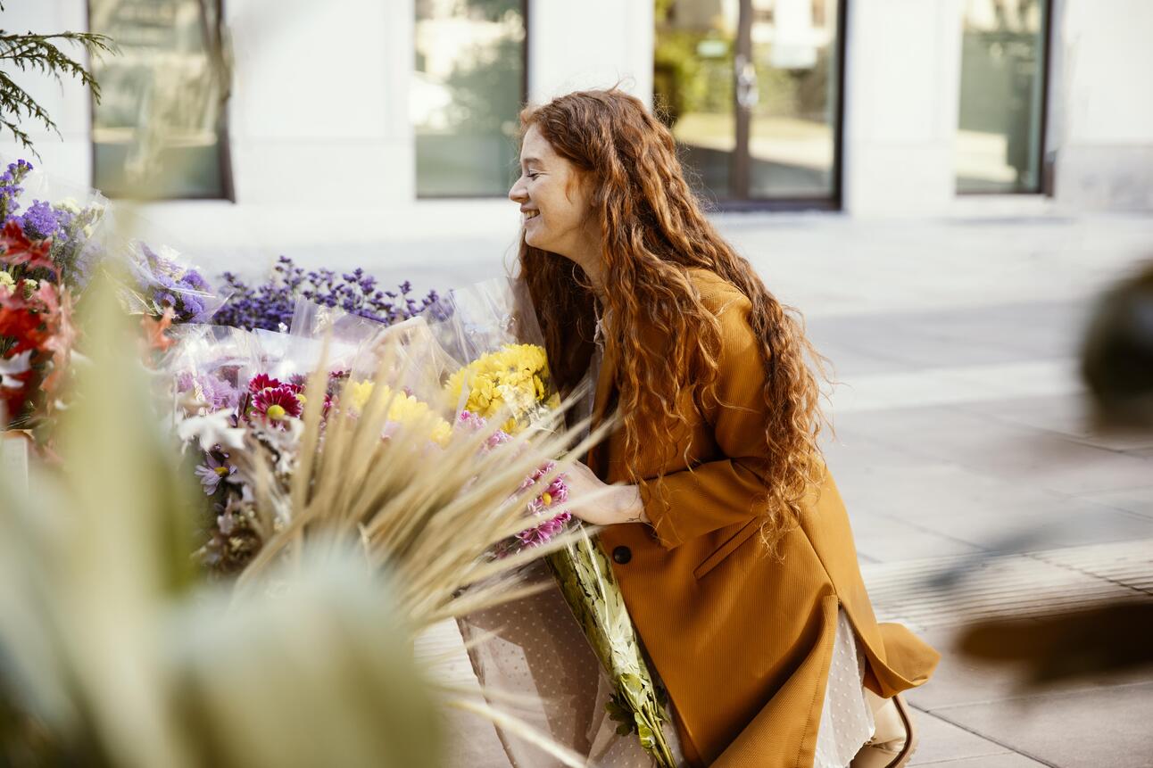 side-view-smiley-woman-getting-spring-flowers-outdoors