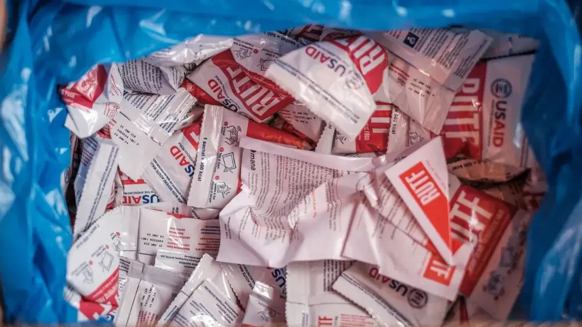 USAID food packets are shown in what appears to be a blue trash bag.