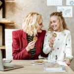Joyful And Laughing Daughter With Her Mother Eating Tasty Chocol
