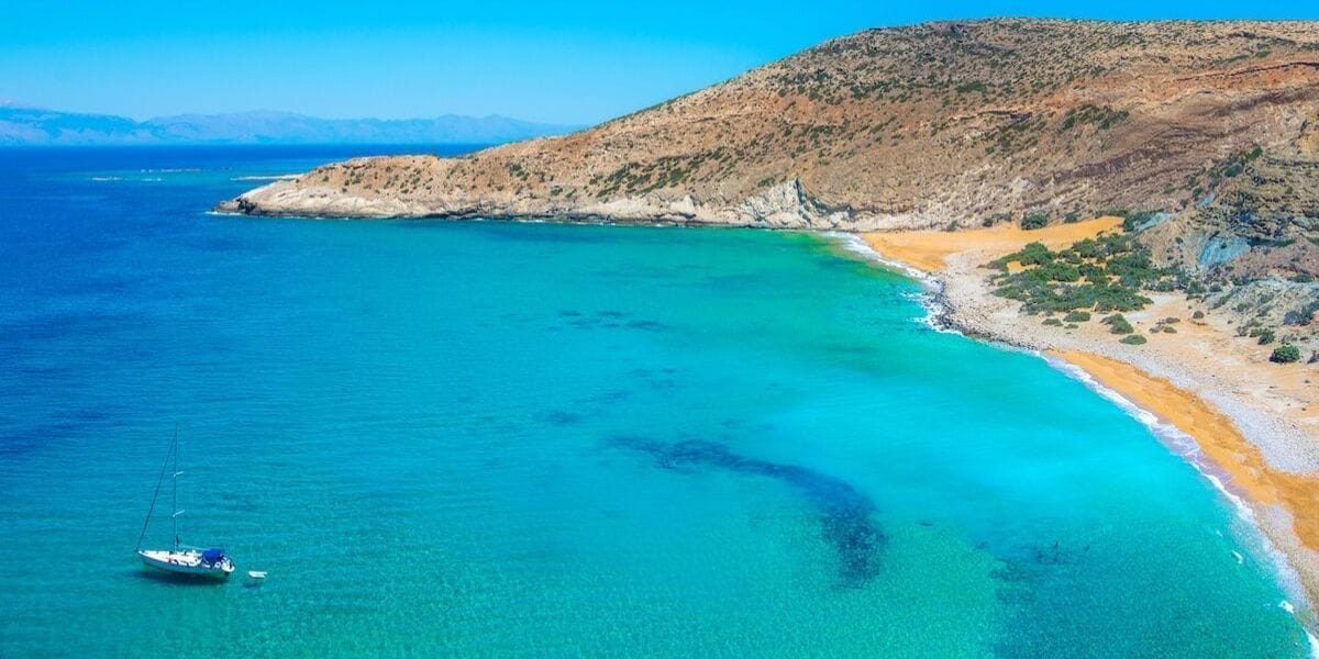 teal waters and a tiny boat by an island
