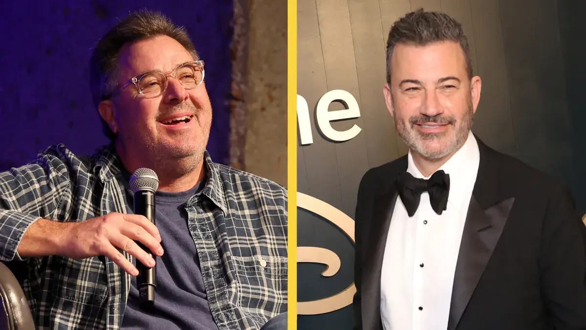 A white man wearing a flannel shirt is pictured next to another white man wearing a black tuxedo. Both men are smiling.