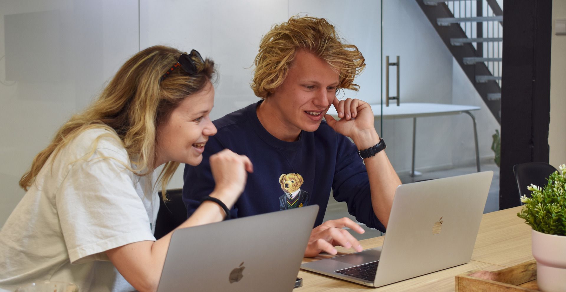 Steffi en Menno van Digitaal Toegankelijk kijken samen naar een laptop en lachen