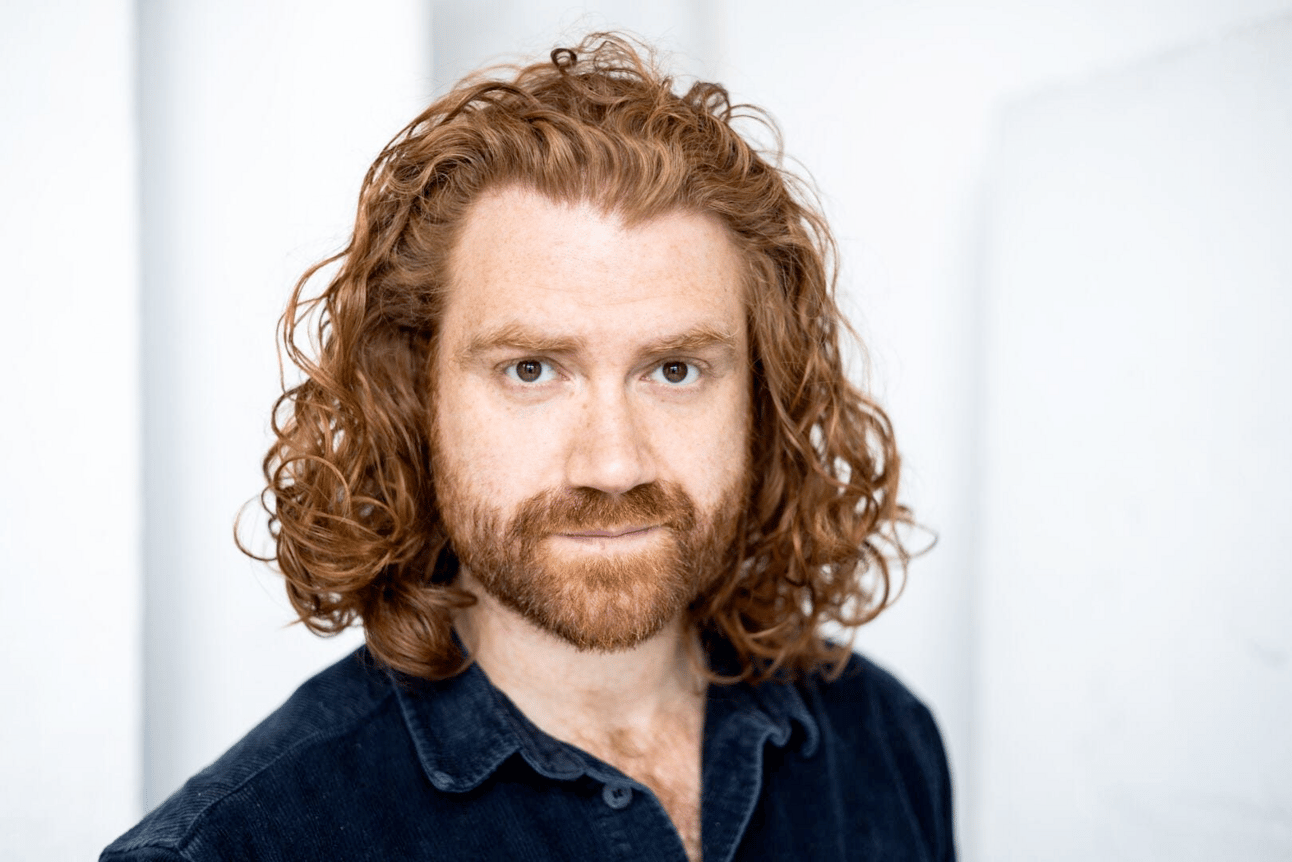 A very handsom white man with a full beard and curly ed hair o his shoulders