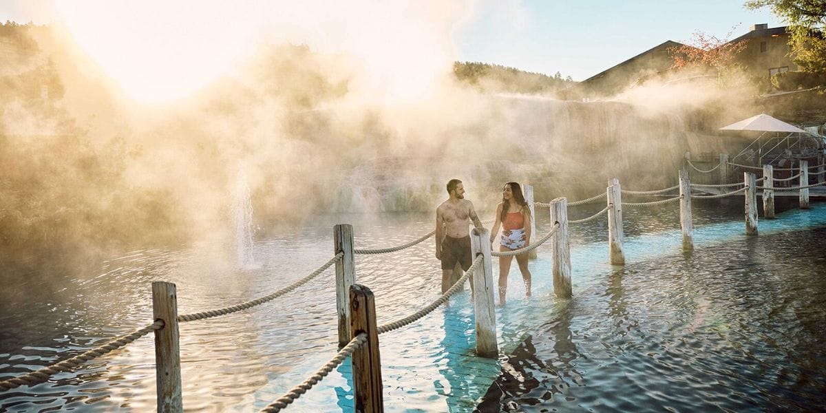 two people walking through a hot spring in the morning