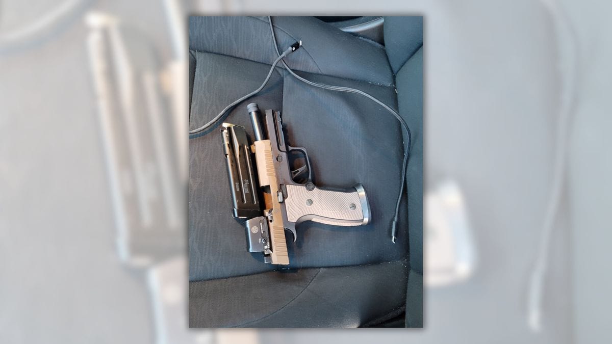 An image shows a gun placed near two charging cables.