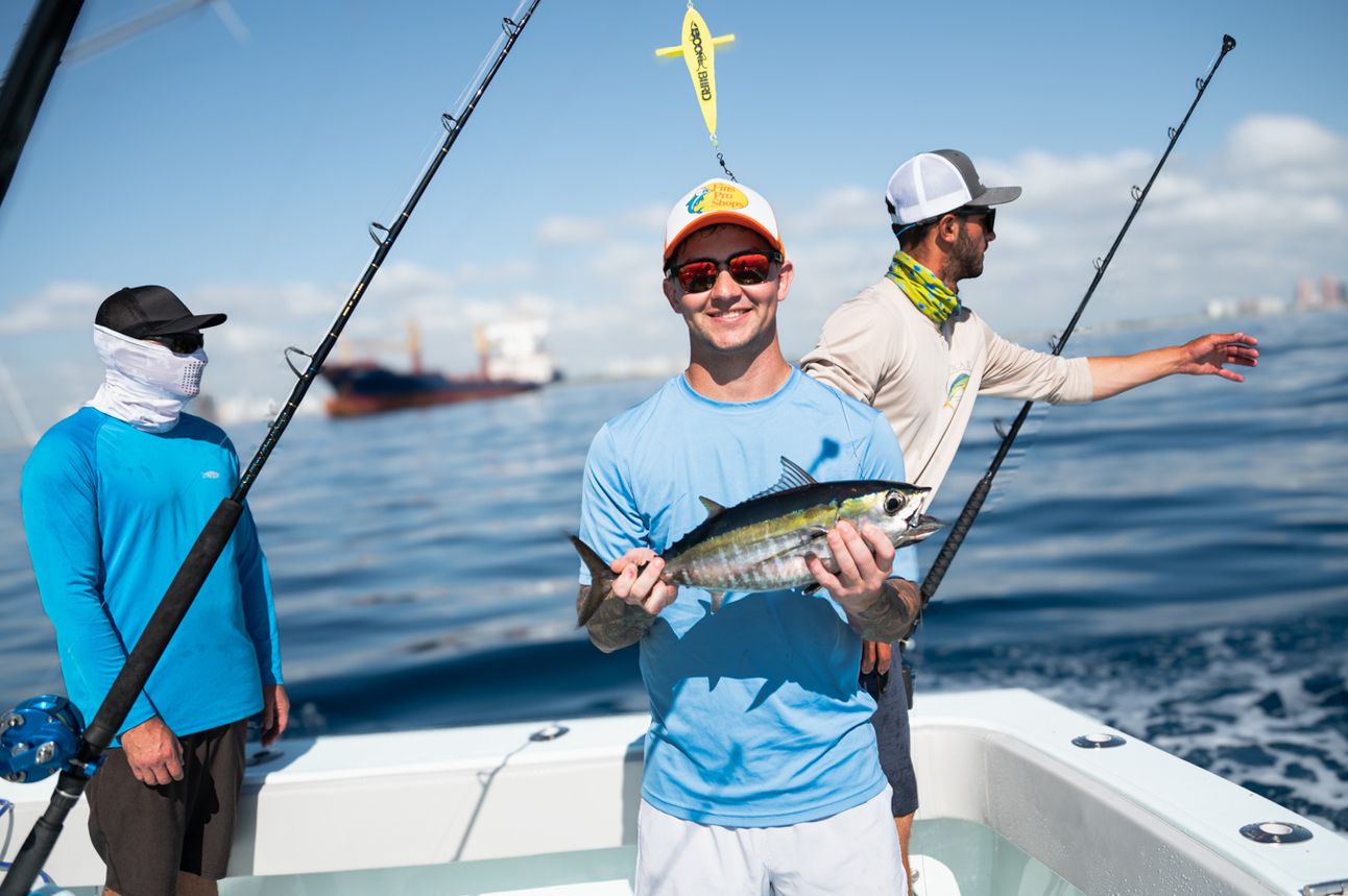 A young man holds a caught fish