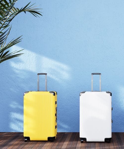 a yellow hardshell luggage and a white one