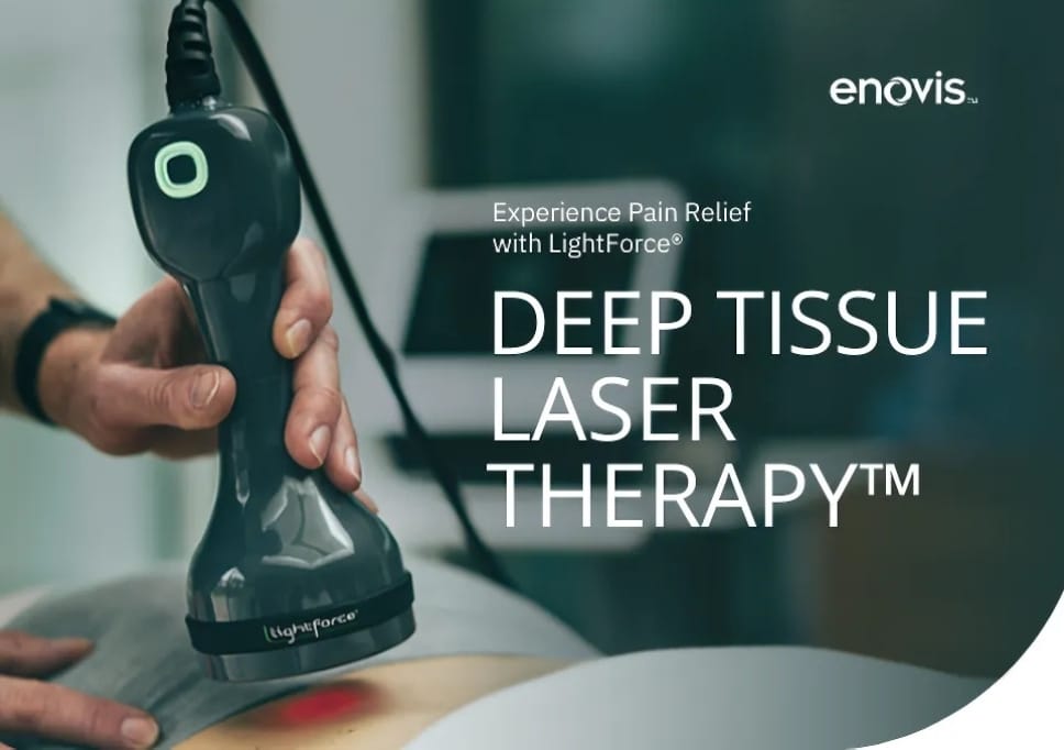 Hand holds wand-like device over patients back with redlight showing on their skin.