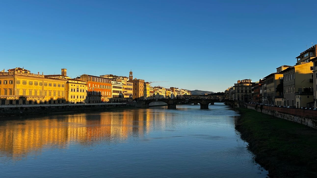The historic Ponte Vecchio in Florence, glowing under the evening lights. A perfect place to toast with a bottle of Rosso di Montepulciano, safely packed in Jimmy the Fox Bottle Italy Wine Travel Bag.