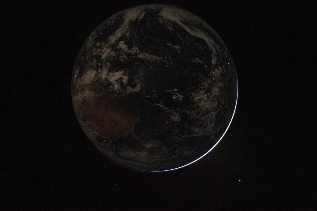 Same as above, but Earth is much darker. Specks of light can be seen across Earth.