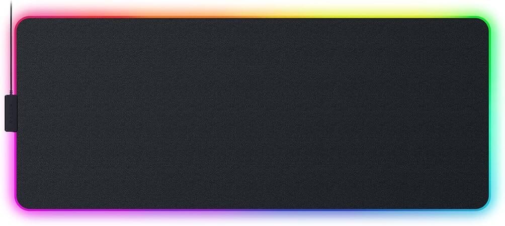Razer Strider Chroma – The Hybrid Hero A hybrid-texture RGB gaming mouse pad with an anti-slip base, glowing beneath a fast-paced Overwatch 2 gaming rig.